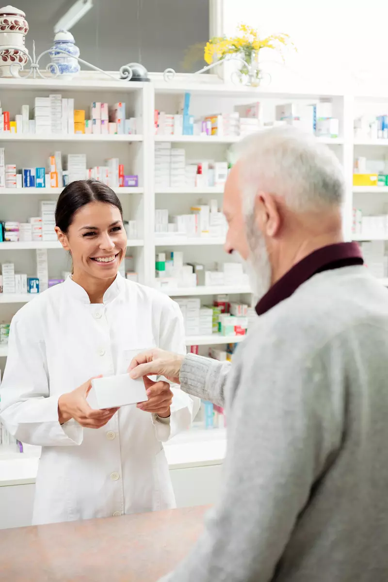 female pharmacist helping older man
