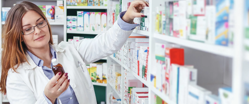 woman pharmacist looking at bottle of medication